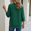 FJØRNA women's summer blouse with V-neck, puff sleeves, and high waist, shown from the back. Light, flowy fabric in natural setting.