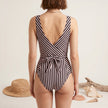 FJØRNA women's summer one-piece swimsuit with V-neck, cut-out design, and striped pattern, shown from the back.