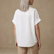 Back view of FJØRNA women's summer denim blouse with short sleeves and wide-leg design, showcasing casual, stylish women's top.