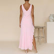 FJØRNA flowing chiffon maxi dress with ruched bodice and ruffled slit, shown from the back with draped fabric and elegant design.