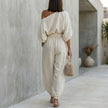 FJØRNA draped one-shoulder top and voluminous lantern pants set, back view showcasing elegant resort chic style.