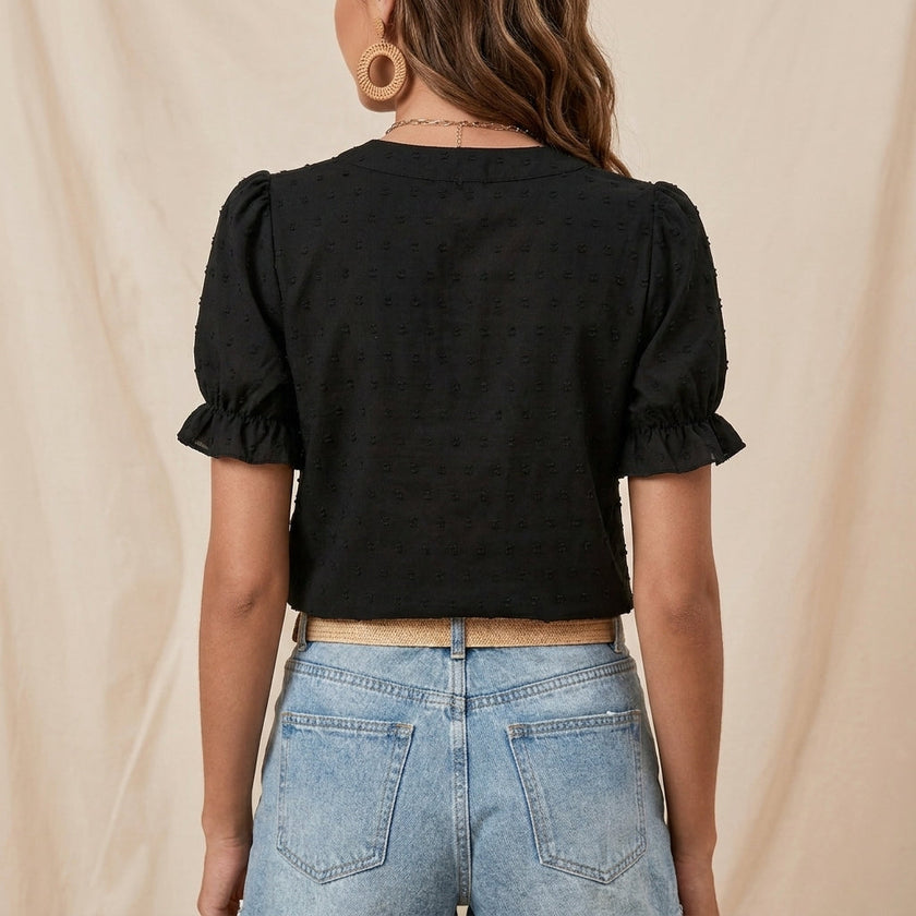 FJØRNA summer women's blouse with floral print, puff sleeves, and ruffle details, shown from the back.