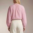 Back view of FJØRNA women's striped cotton summer blouse, showcasing relaxed fit and stylish design for warm weather.