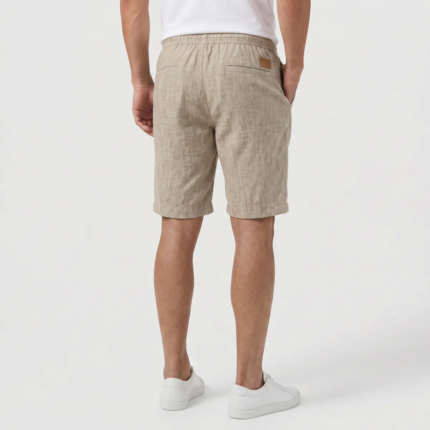 Back profile of men's khaki linen shorts by FJØRNA with elasticated waist and drawstring, perfect for summer beachwear.