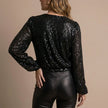 FJØRNA women's summer blouse with V-neck and long sleeves featuring sequin embellishments, shown from the back.