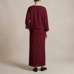 FJØRNA two-piece textured woven skirt suit with draped high-waist silhouette, shown from the back.