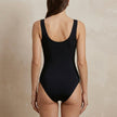 FJØRNA women's summer one-piece swimsuit with V-neck, bodycon fit, and colorful print, shown from the back.