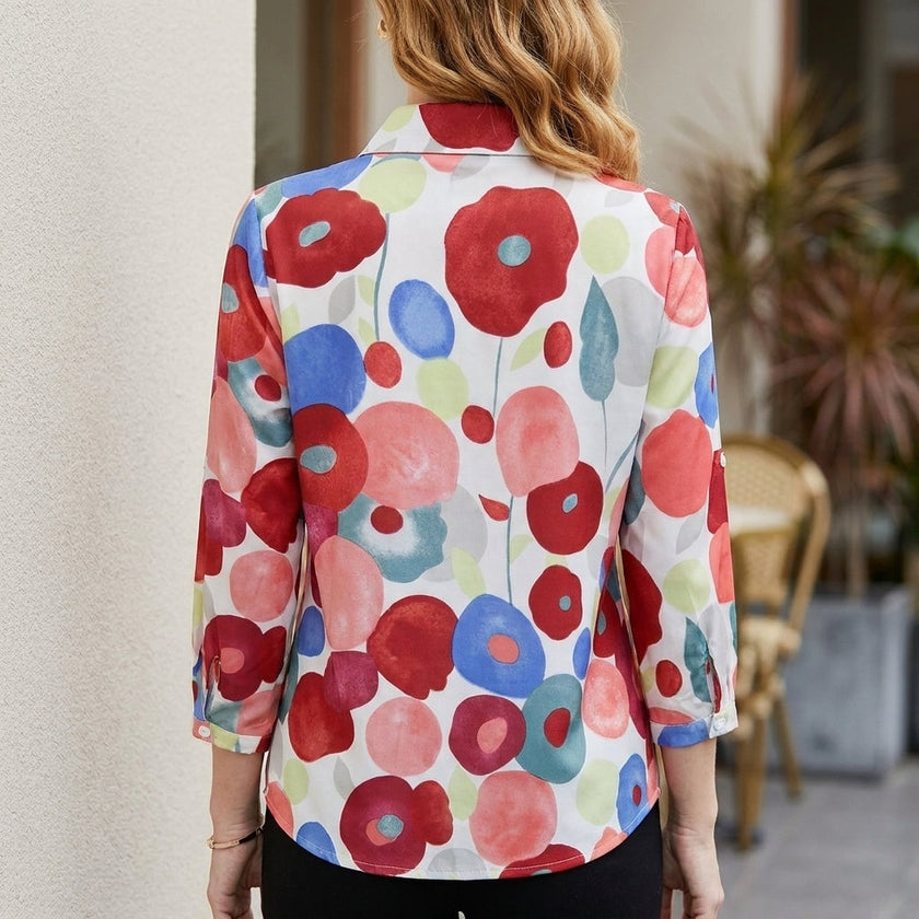 Back view of FJØRNA women's floral long sleeve denim summer blouse, showcasing ruffled cuffs and vibrant floral pattern.