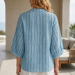 FJØRNA women's summer blouse featuring striped linen fabric, button front, and relaxed fit, shown from the back.