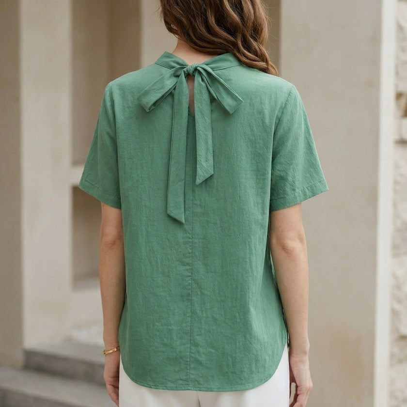 FJØRNA women's summer blouse with high neck and short sleeves, shown from the back in a light, breathable fabric.
