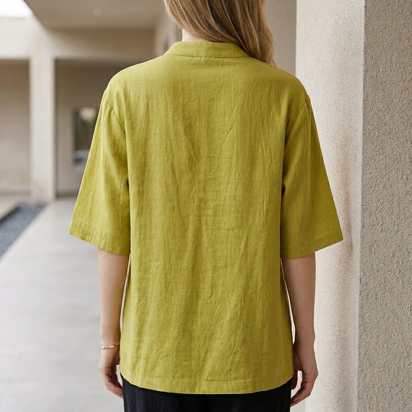 Back view of FJØRNA women's summer denim blouse with pockets, featuring a relaxed fit and casual style.