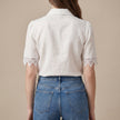 Back view of FJØRNA women's summer linen blouse with V-neck and puff sleeves, lightweight and breathable for warm weather.
