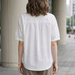 FJØRNA women's summer blouse with puff sleeves, denim fabric, button front, casual style, shown from the back.