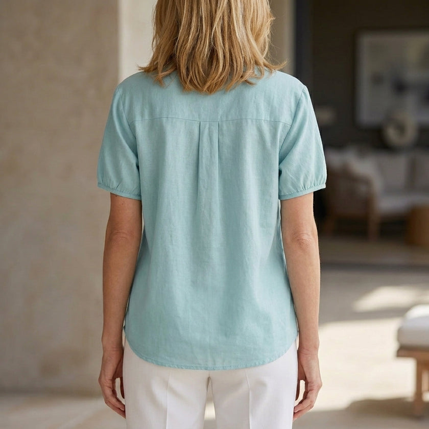 Back view of FJØRNA women's summer blouse with puff sleeves, denim fabric, button front, lightweight design, perfect for warm weather.