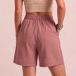Back view of FJØRNA women's linen summer shorts with high waist, breathable fabric, and functional pockets.