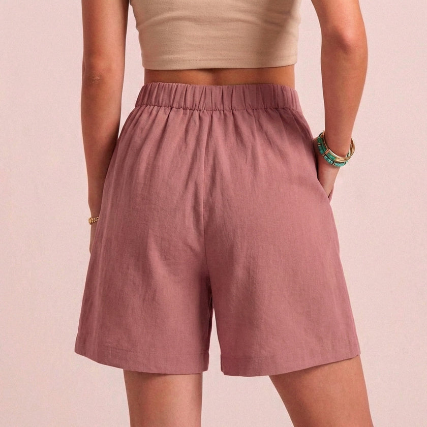 Back view of FJØRNA women's linen summer shorts with high waist, breathable fabric, and functional pockets.