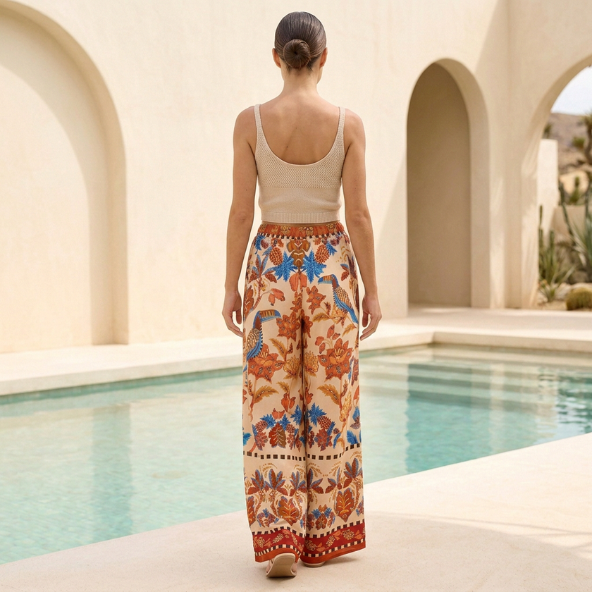 Back view of FJØRNA women's summer cotton trousers with drawstring waist and wide-leg design, showcasing relaxed fit and casual style.