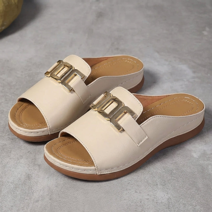 Beige FJØRNA orthopedic slide sandals with buckle detail and contrast stitching, showcasing comfortable footbed and stylish design.