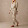 Beige linen two-piece set by FJØRNA with boat neck blouse and drawstring pants, casual and relaxed fit.