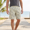 Men's beige loose-fit knee-length beach shorts with tropical leaf pattern and side pockets, by FJØRNA.