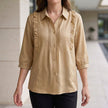 Beige summer blouse for women by FJØRNA featuring denim fabric and ruffle details, perfect for warm-weather styling.