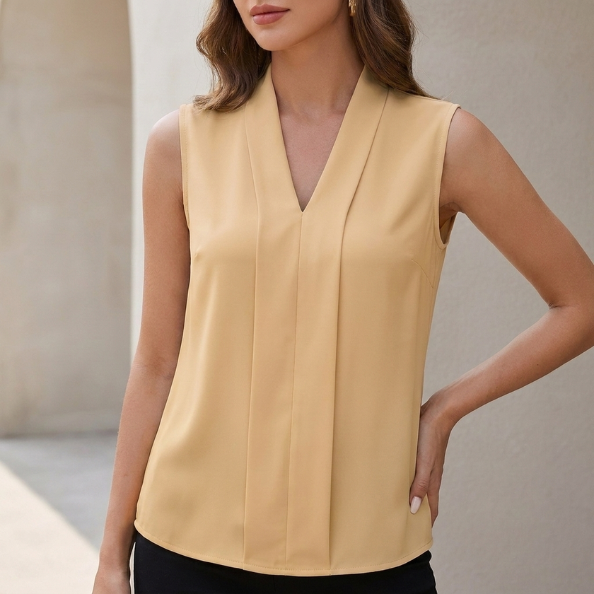 Beige sleeveless V-neck blouse for women by FJØRNA with front pleats and tailored fit, styled as a modern, elegant top.
