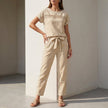 Beige FJØRNA women's two-piece co-ord set with mesh pockets, featuring a stylish top and matching pants for casual wear.