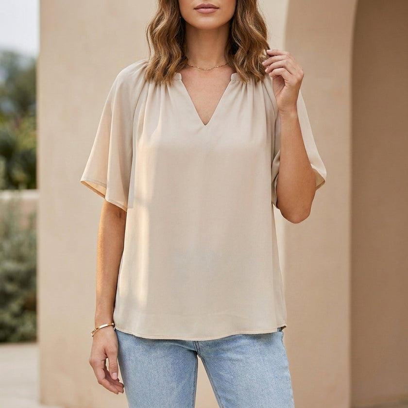 Beige women's summer blouse with V-neck and flutter sleeves by FJØRNA, styled for a casual, breezy look.