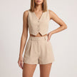 Beige women's two-piece co-ord set with pleated V-neck top and matching skirt by FJØRNA, stylish and elegant for casual or dressy wear.
