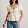 Beige summer blouse for women with sweetheart neckline and puff sleeves, by FJØRNA, shown on a model.