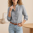 Black FJØRNA seersucker blouse for women with ruffle trim and textured summer design, showcasing a stylish, lightweight top.