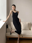 FJØRNA black butterfly back midi dress with a fitted waist, flowing skirt, and elegant butterfly back detail.