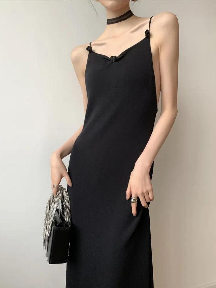 FJØRNA black butterfly back midi dress featuring a sleek silhouette and elegant design, showcased on a model.