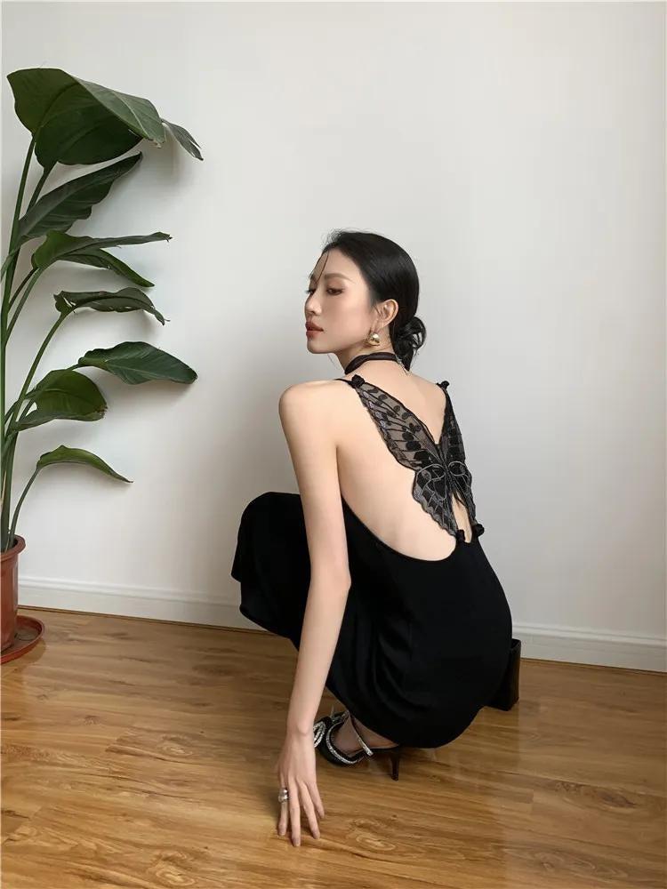 Black butterfly back midi dress by FJØRNA, featuring a sleek silhouette and elegant design, shown in a stylish black fabric.