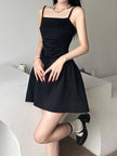 Black sleeveless mini dress by FJØRNA, close-up of sleek black dress with fitted silhouette and minimalist style.