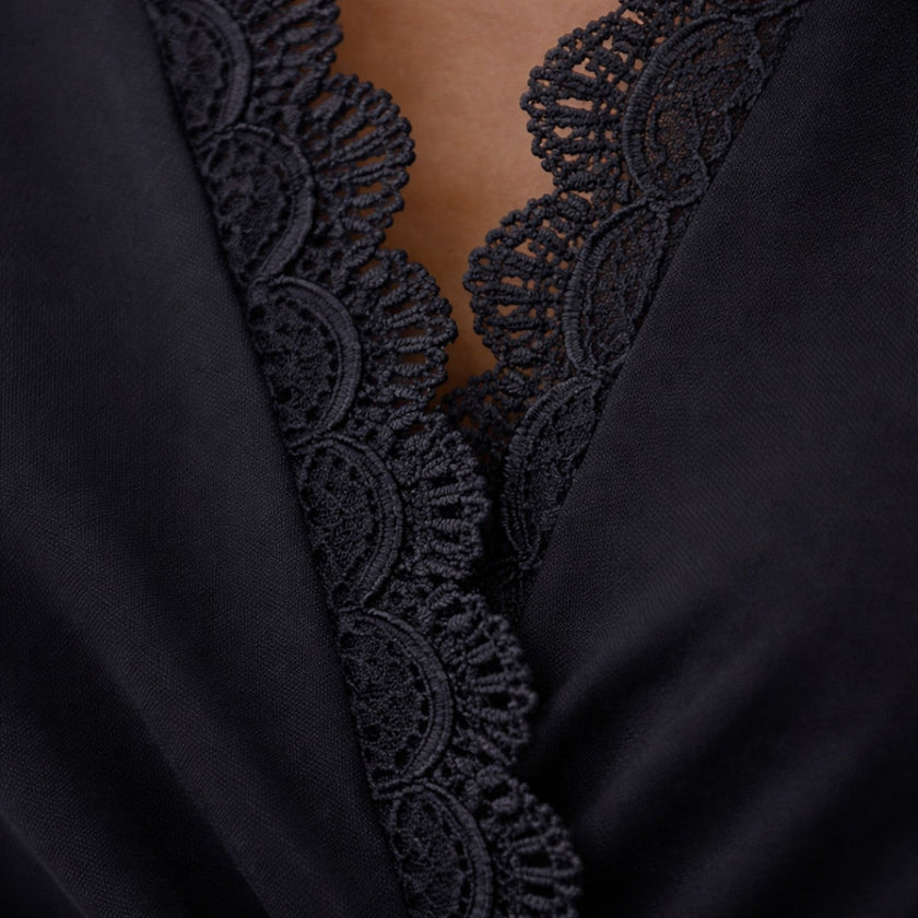 Women's black midi dress with lace sleeves by FJØRNA, featuring a slim fit and elegant design perfect for special occasions.