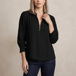 Black FJØRNA women's summer blouse with long sleeves and smocked details, featuring a relaxed, stylish fit for warm weather.