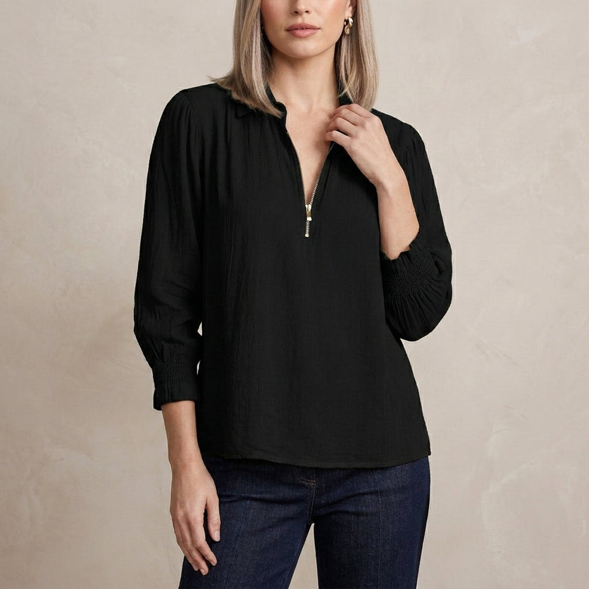 Black FJØRNA women's summer blouse with long sleeves and smocked details, featuring a relaxed, stylish fit for warm weather.