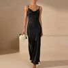 Black satin fitted cowl neck maxi dress with spaghetti straps by FJØRNA, perfect for elegant evening occasions.