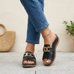 Black FJØRNA orthopedic slide sandals with buckle detail and contrast stitching, showcasing comfortable, supportive footwear.