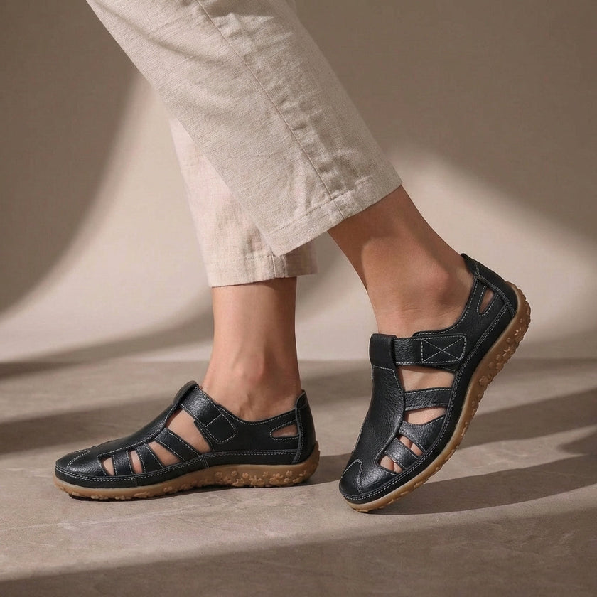 Black FJØRNA orthopedic closed-toe sandals with cutout details and a comfortable fit, designed for supportive footwear.
