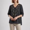 Black floral V-neck linen summer blouse for women by FJØRNA, featuring a slit design and lightweight, breathable fabric.