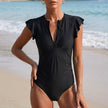 Black FJØRNA summer one-piece swimsuit for women with ruffle and ruched design, perfect for stylish swimwear.