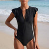 Black FJØRNA summer one-piece swimsuit for women with ruffle and ruched design, perfect for stylish swimwear.