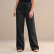 Black FJØRNA summer trousers for women, high-waist cotton pants, shown on a model highlighting the relaxed fit and stylish design.