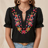 Black floral summer blouse for women with puff sleeves and ruffle details by FJØRNA, perfect for warm weather and casual wear.
