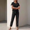 Black FJØRNA women's two-piece co-ord set with mesh pockets, featuring a stylish top and matching pants for a modern look.