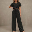 FJØRNA Coastal Breeze textured two-piece lounge set with wide-leg black pants and matching top, stylish and comfortable for relaxed wear.