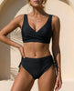 Black FJØRNA fitted wrap front bikini with wide straps, showcasing the stylish design and supportive fit on a model.
