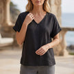 Black V-neck short sleeve denim blouse for women by FJØRNA, stylish summer top with a relaxed fit and classic denim look.